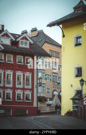 11/03/2024 - Moody Street Scene a Ortisei, Italia: Tranquilla città alpina catturata con tenui toni freddi che creano un'atmosfera suggestiva e pittoresca Foto Stock