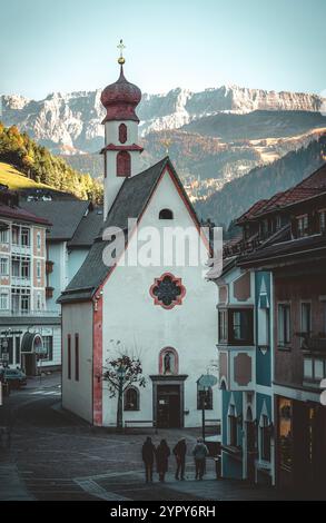 11/03/2024 - Moody Street Scene a Ortisei, Italia: Tranquilla città alpina catturata con tenui toni freddi che creano un'atmosfera suggestiva e pittoresca Foto Stock