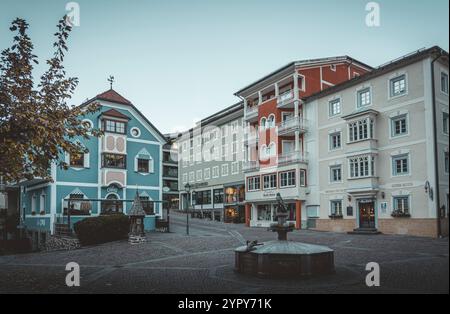 11/03/2024 - Moody Street Scene a Ortisei, Italia: Tranquilla città alpina catturata con tenui toni freddi che creano un'atmosfera suggestiva e pittoresca Foto Stock