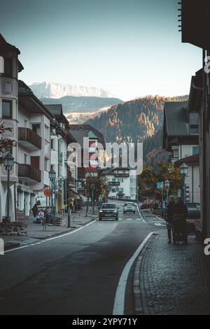 11/03/2024 - Moody Street Scene a Ortisei, Italia: Tranquilla città alpina catturata con tenui toni freddi che creano un'atmosfera suggestiva e pittoresca Foto Stock