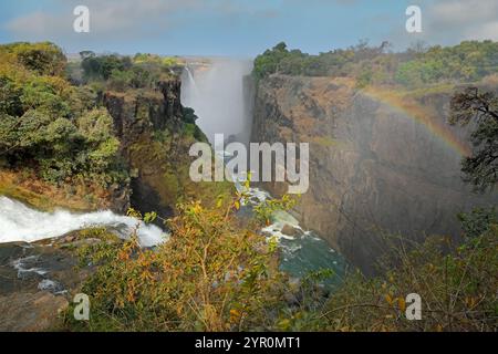 Vista panoramica della famosa cascata Victoria con arcobaleno nel fiume Zambesi, Zimbabwe Foto Stock