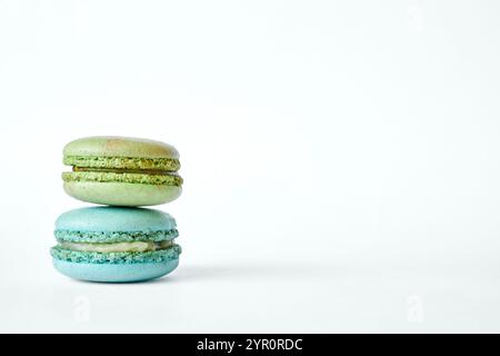 Pila di due coloratissimi macaron francesi, torte dai sapori diversi, menta e mela. piramide di dessert fatti in casa, macaroon acquamarina, verde c Foto Stock