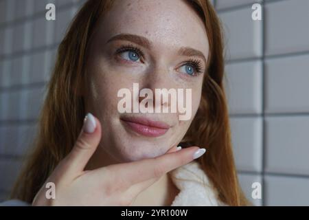 Una giovane donna riflettente in un ambiente moderno ed elegante, che simboleggia eleganza e bellezza Foto Stock