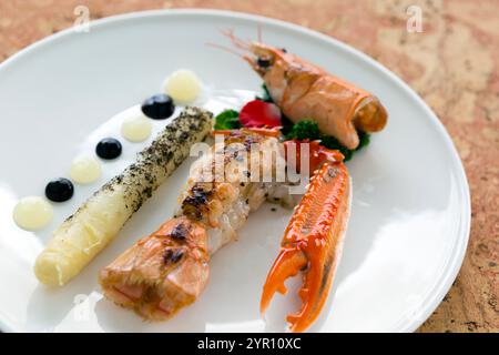 Langoustine della Bretagna servita con aparagus bianco sbiancato e salsa yuzu. Foto Stock