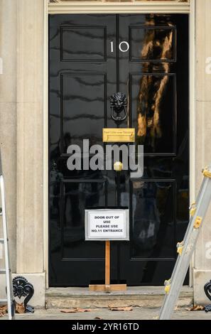 Londra, Regno Unito. La porta del 10 Downing Street è temporaneamente fuori uso mentre l'albero di Natale è installato e decorato. Foto Stock