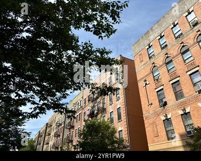 Fila di condomini in mattoni con fuochi d'incendio sotto il cielo blu Foto Stock