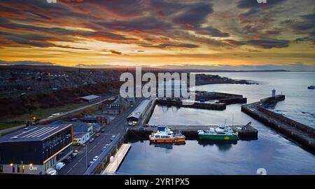 Buckie Harbour Moray Coast Scozia una turbina eolica ormeggiata al tramonto invernale e un nuovo edificio Ocean Wave Foto Stock