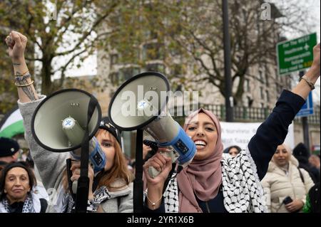 Il 30 novembre 2024 migliaia di manifestanti hanno chiesto un cessate il fuoco a Gaza. Due giovani donne con megafoni. Foto Stock