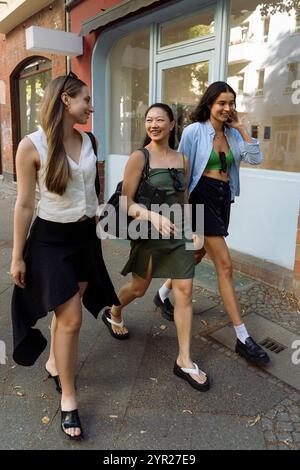 Amici multirazziali sorridenti che parlano mentre passeggiano in città Foto Stock