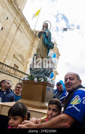 Cospicua, Malta - 1 dicembre 2024. Festa religiosa Processione con Statua e partecipanti devoti Foto Stock