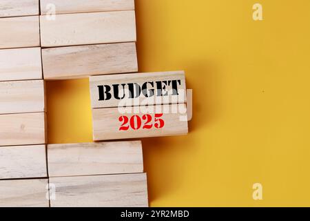 Simbolo budget 2025. Blocchi di legno con parole budget 2025. Bellissimo sfondo giallo. Business and budget 2025. Copia spazio. Foto Stock