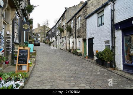 Guardando in alto la strada acciottolata Howarth Main St Foto Stock