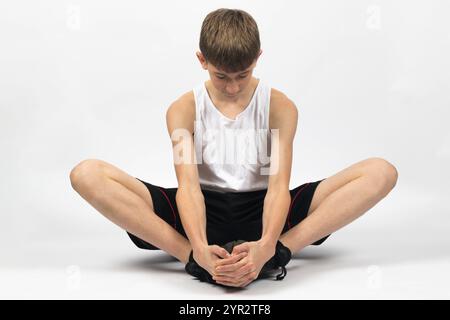 Adolescente di quindici anni che si spacca la farfalla, girato in studio su uno sfondo bianco Foto Stock