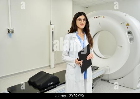 Un'attraente dottoressa si trova in un'unità radiologica, con un portadocumenti. Foto Stock