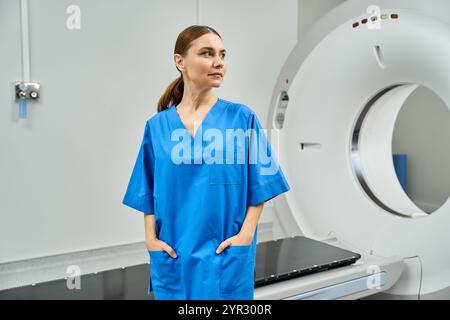 Un attraente medico femminile si trova con sicurezza accanto alle apparecchiature radiologiche avanzate in un ospedale. Foto Stock