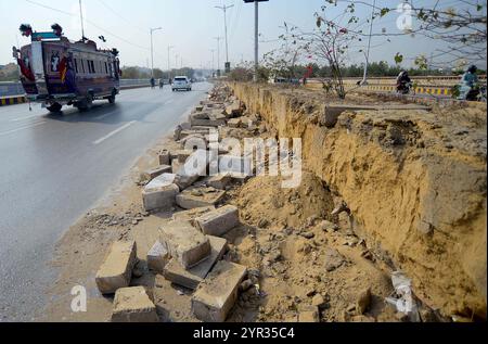 Vista dei danni dopo i lavori di costruzione, la cintura verde della strada del ponte Natha Khan, poiché il lento ritmo dei lavori sta creando problemi per i pendolari e chiedono al reparto interessato di completare i lavori il prima possibile, situato sulla strada Shahrah- e-Faisal a Karachi lunedì 2 dicembre 2024. Foto Stock