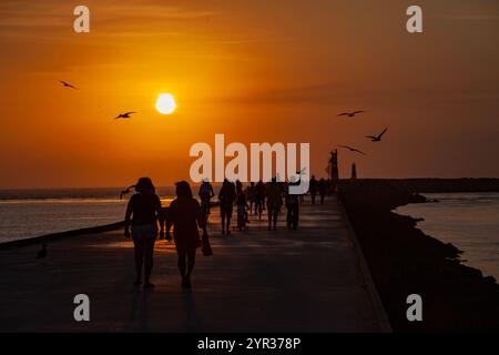 Persone che camminano al tramonto. Spiaggia di barra. Praia da barra, Ilhavo, Portogallo - città vicino alla baia, al mare e all'oceano. Foto Stock
