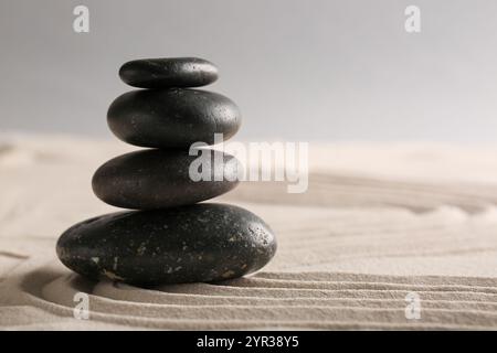 Pila di pietre su sabbia chiara con motivi nel giardino di roccia giapponese. Concetto Zen Foto Stock