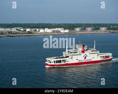 Il traghetto ro-ro della Red Funnel Line Red Eagle naviga da Southampton all'Isola di Wight con la costa dell'Hampshire sullo sfondo. Foto Stock