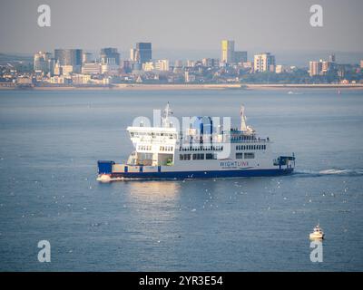 I traghetti Wightlink Isle of Wight, la nave ro-ro St Faith, salpa sul Solent vicino a una piccola barca con lo sfondo di Portsmouth alle spalle in estate. Foto Stock