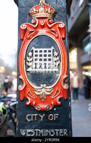 Vecchio cartello di confine della città di Westminster con una portcullis con le sue catene con il contorno rosso e la corona in cima. Londra Regno Unito Foto Stock