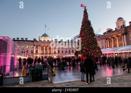 Divertimento serale invernale natalizio sulla pista di pattinaggio sul ghiaccio della Somerset House a Londra, Inghilterra Foto Stock