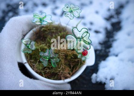 Pentola bianca con quattro foglie e coccinello - decorazione fatta a mano. Simbolo di buona fortuna per l'anno nuovo. Foto Stock