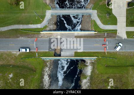 Auto delle forze dell'ordine presso il cantiere stradale. Blocco stradale in fase di ricostruzione del ponte stradale danneggiato distrutto dal fiume dopo che l'acqua di inondazione ha lavato via l'asfalto Foto Stock