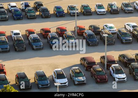 Ampio parcheggio del concessionario locale con molti veicoli nuovi parcheggiati in vendita. Sviluppo dell'industria automobilistica americana e distribuzione del produttore Foto Stock