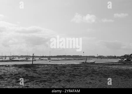 Emsworth, Hampshire, Inghilterra. 26 agosto 2024. Paesaggio nuvoloso in scala di grigi sopra il porto con barche sull'acqua con bassa marea. Foto Stock