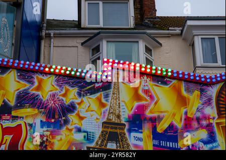 Vistosi negozi sul lungomare di Bridlington, East Yorkshire, con vivaci cartelli per negozi di dolci, gelaterie e divertimenti. Foto Stock