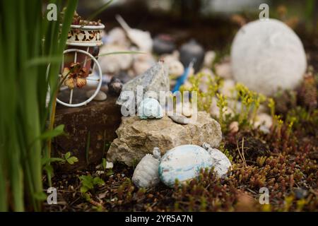 Un incantevole giardino in miniatura caratterizzato da colorate pietre decorative ed elementi vari Foto Stock