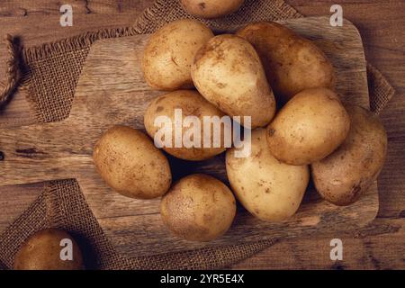 Patate crude, sparse su un tagliere, primo piano, nessuna gente Foto Stock