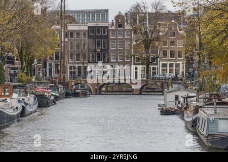 Case sul canale con barche e un piccolo ponte in primo piano, Amsterdam, Paesi Bassi Foto Stock
