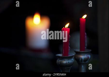 Due candele rosse che bruciano nel buio, una luce soffusa sullo sfondo, borken, muensterland, germania Foto Stock