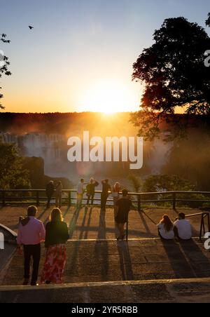 Le cascate dell'Iguazu tramontare; i turisti che guardano il tramonto dal lato brasiliano delle cascate dell'Iguazú; il turismo brasiliano nel Parco nazionale delle cascate dell'Iguazú, in Brasile, viaggiano. Foto Stock