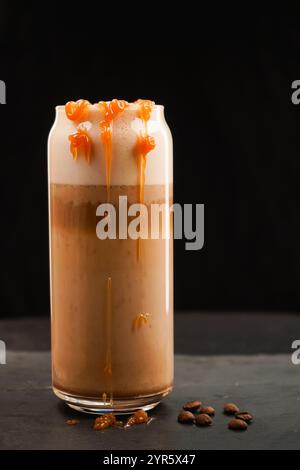 Caffè al latte caramello ghiacciato in un bicchiere alto con sciroppo e panna montata. Foto Stock