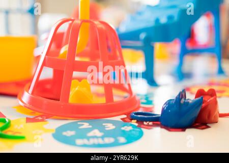 Colorato gioco educativo per bambini con forme e pezzi in plastica sul tavolo Foto Stock