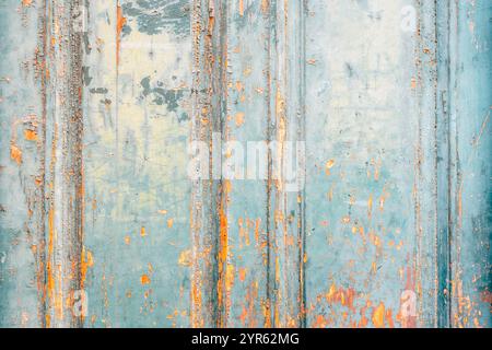 Primo piano della struttura delle porte in legno turchese con vernice sbucciata e accenti arancioni rustici. Foto Stock