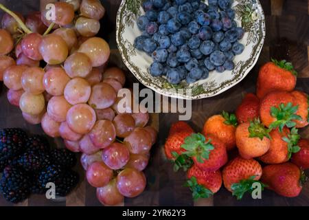 Bacche e uva fresche assortite su tavola di legno Foto Stock