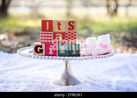 È un annuncio per ragazze con Baby Blocks e Booties all'aperto Foto Stock