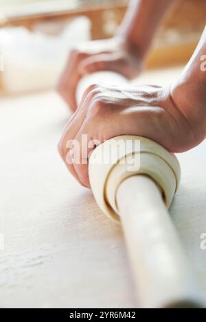 Foto del processo di stendere l'impasto di noodle udon fatte a mano con un mattarello. Foto Stock