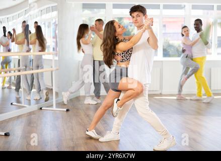 Giovane uomo e donna che praticano salsa dance in coppia nella sala di allenamento Foto Stock