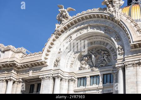 Una vista dettagliata della facciata ornata del Palacio de Bellas Artes, che mostra sculture e dettagli architettonici sotto un cielo azzurro. Foto Stock