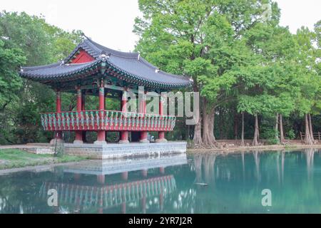 Padiglione pagoda rosso in stile coreano con riflessi lungo un lago verde smeraldo. Foto scattata al Denman Estate Park di San Antonio Foto Stock