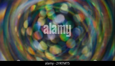 Coriandoli olografici sfocati. Luce bokeh. Perdita sfocata, raggi verdi gialli multicolori, sfarfallio dell'arcobaleno, luce parassita della lente del fascio su sfondo astratto. Foto Stock