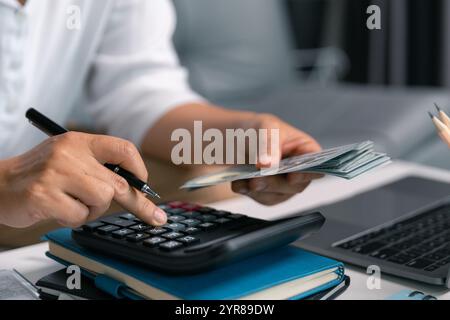 Dopo aver esaminato i documenti finanziari e i documenti cartacei, ha calcolato attentamente ogni deduzione fiscale prima della presentazione, sperando in un rimborso sostanziale sul suo sito Foto Stock