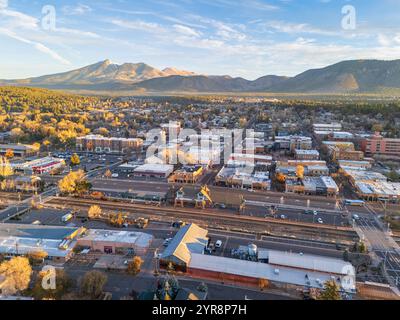 Vista panoramica aerea del centro di Flagstaff, Arizona, all'alba in autunno, con il centro città, la stazione ferroviaria e i picchi di San Francisco Foto Stock