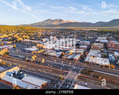 Vista panoramica aerea del centro di Flagstaff, Arizona, all'alba in autunno, con il centro città, la stazione ferroviaria e i picchi di San Francisco Foto Stock