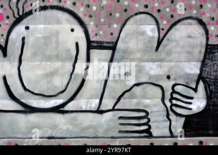 Graffiti, disegnati con un disegno bianco, nero, rosa a spruzzo di un uomo a forma di sorriso, che abbraccia un lepre con un cuore incrociato. Foto Stock